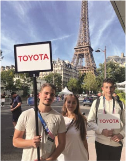 people holding toyota sign