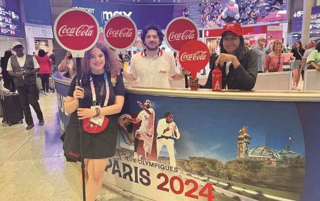 people holding coke sign