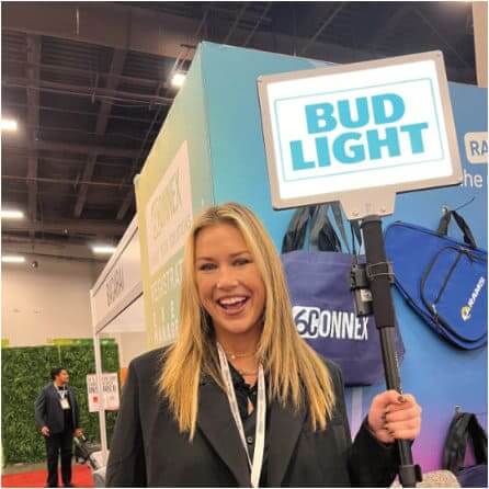 woman smiling at the camera while holding a bud light